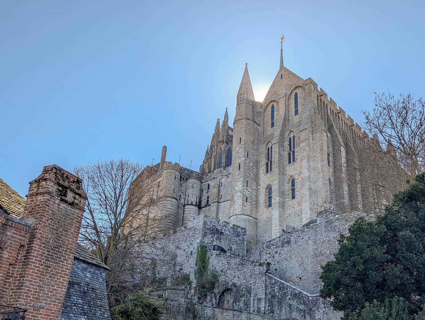 Mont St-Michel Abbey with sun behind it