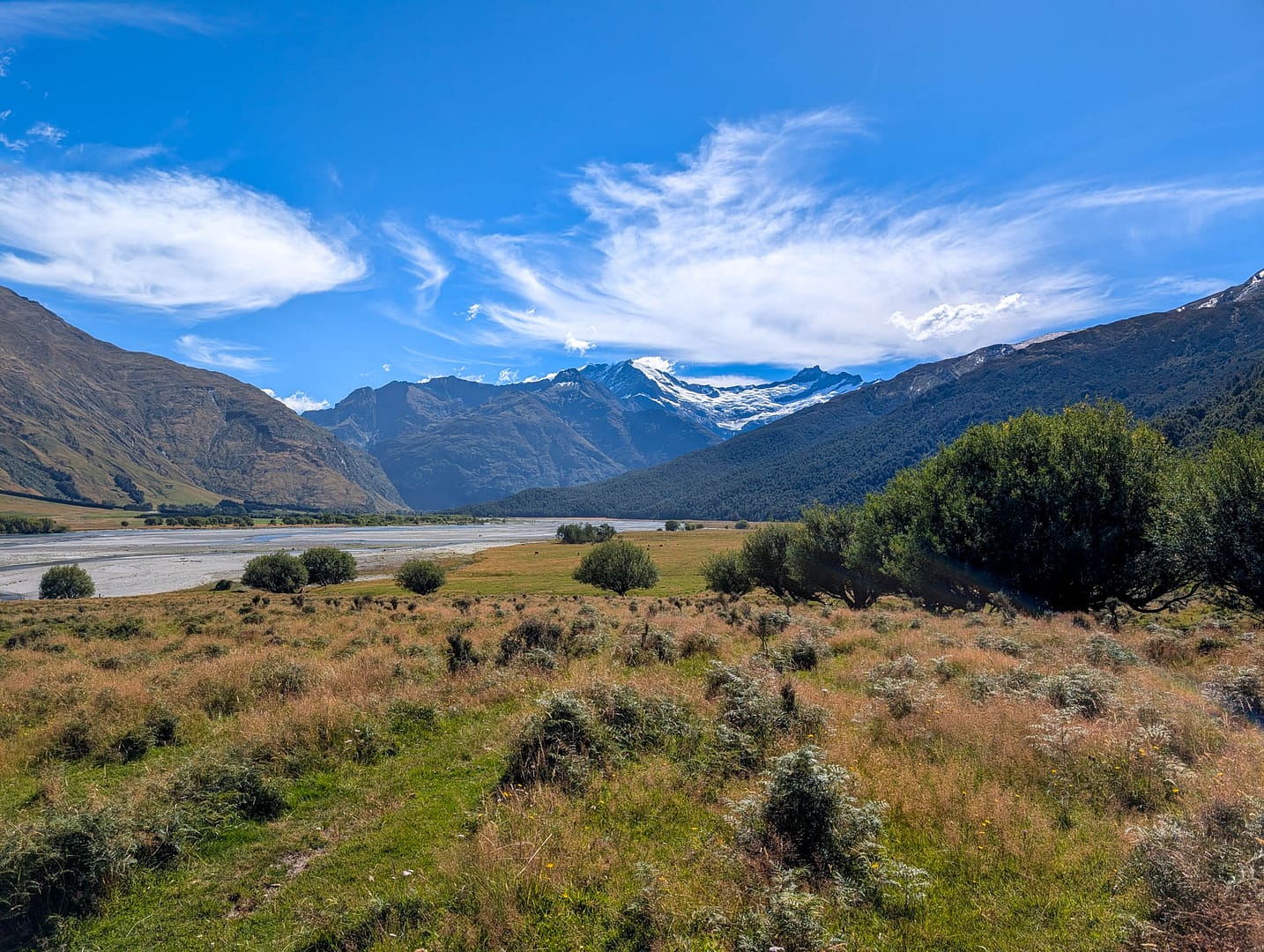 grassy plain with river and mountains beyond