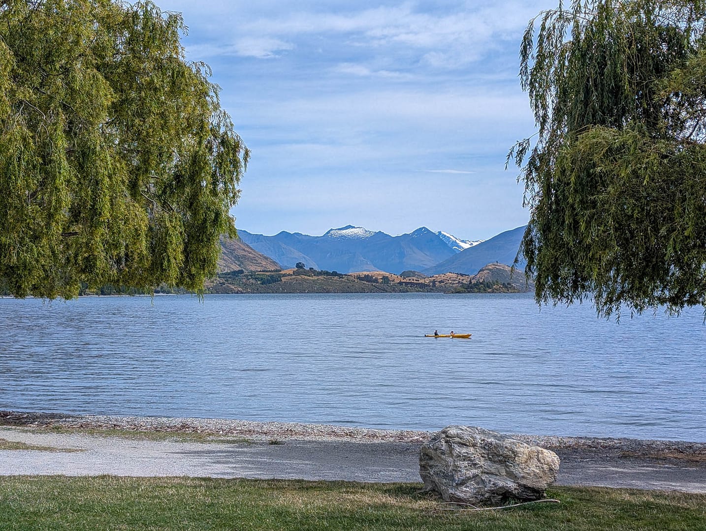 lake with kayak and mountains in background