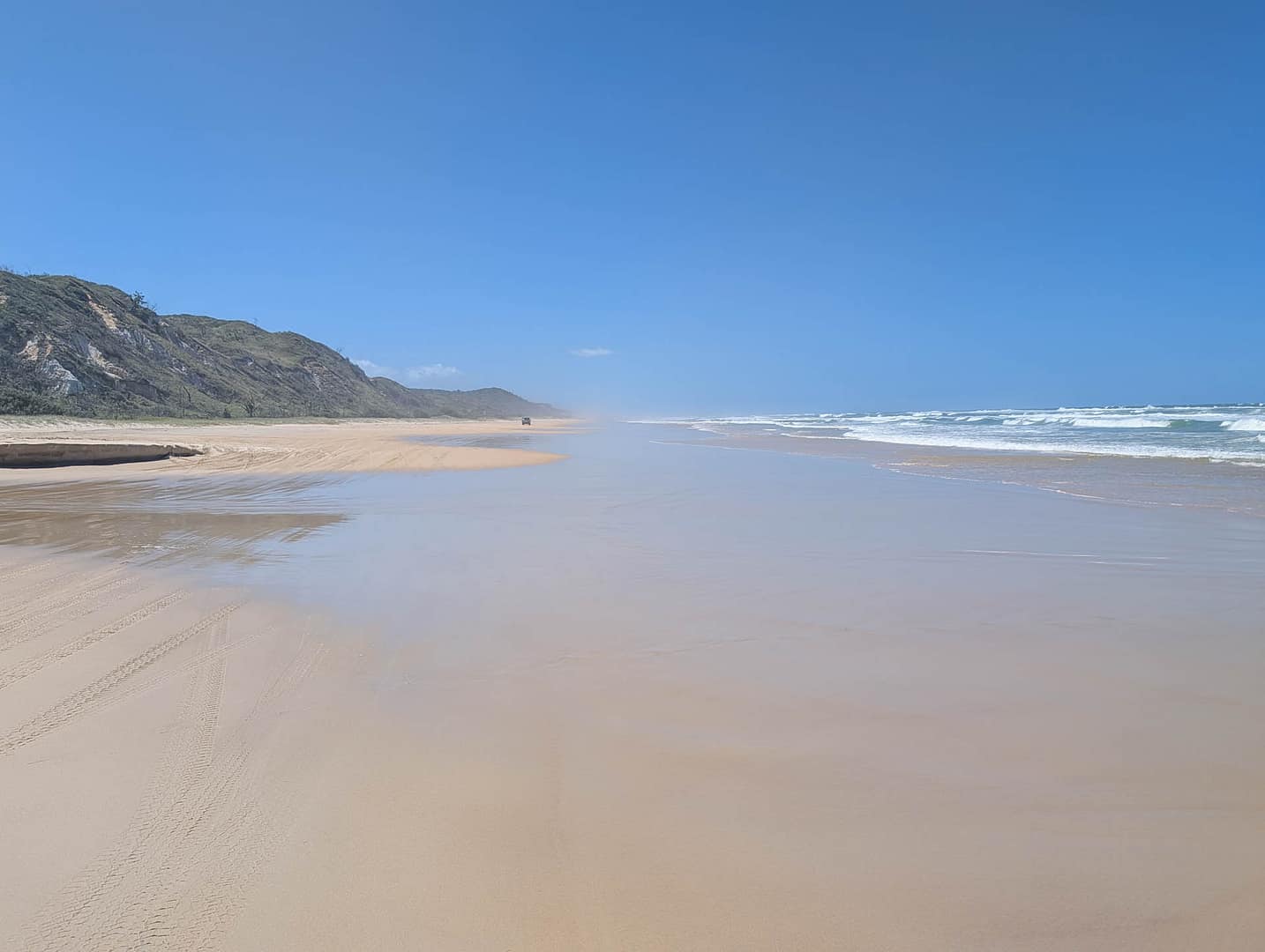 beach with vehicle in the distance