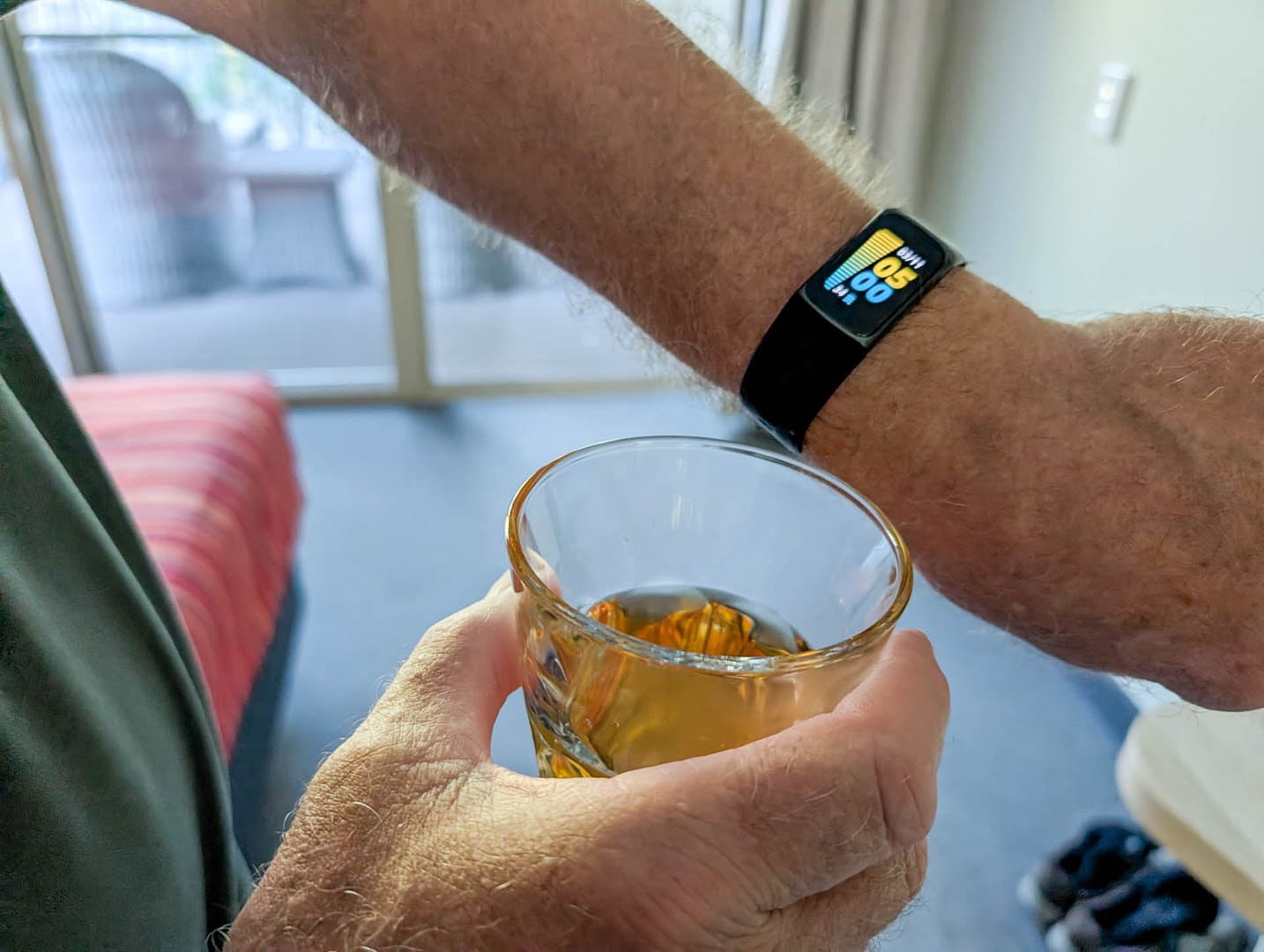 watch showing 5:00 and drink in hand