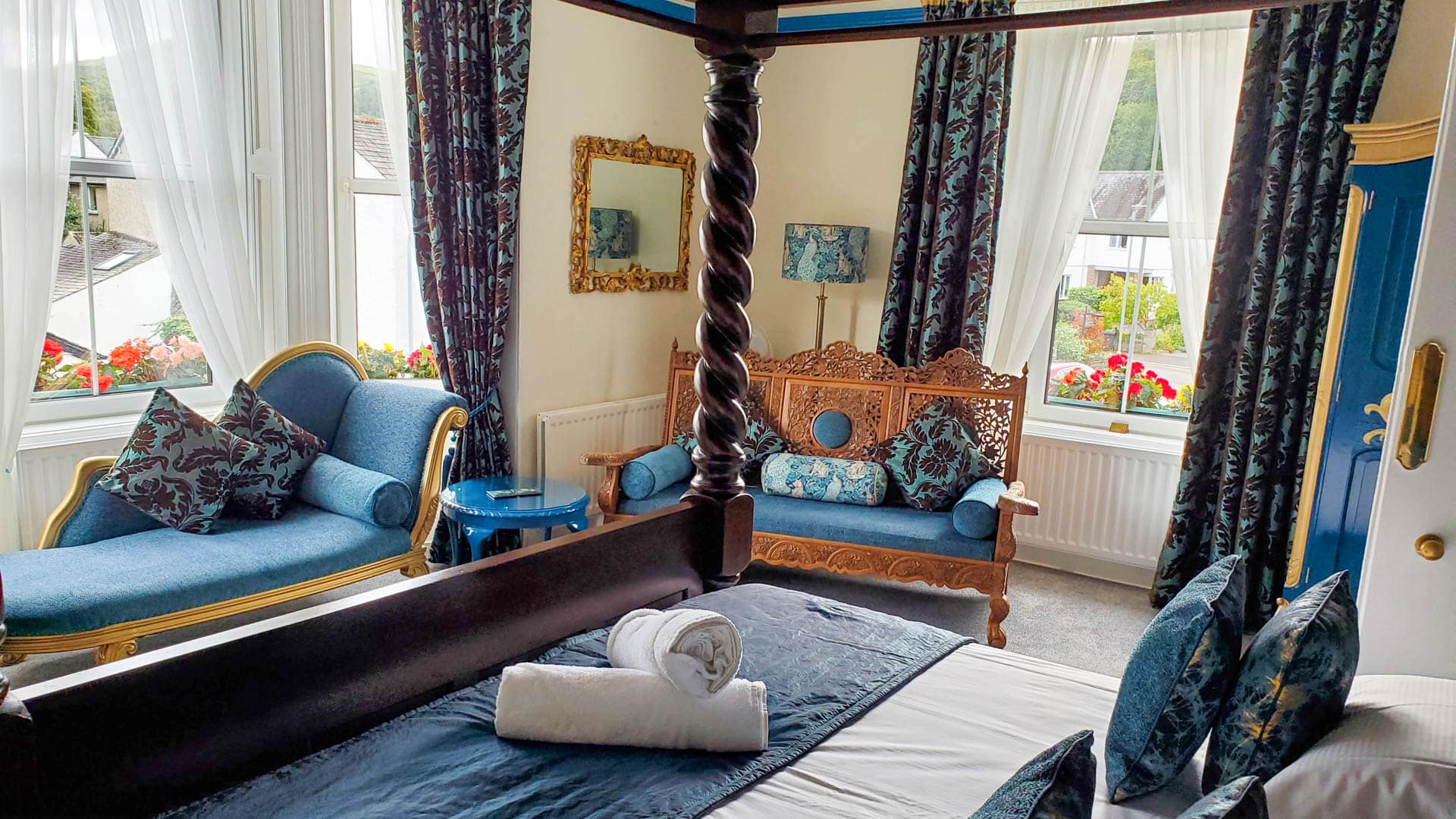 beautiful blue and brown room with canopy bed and fainting couch