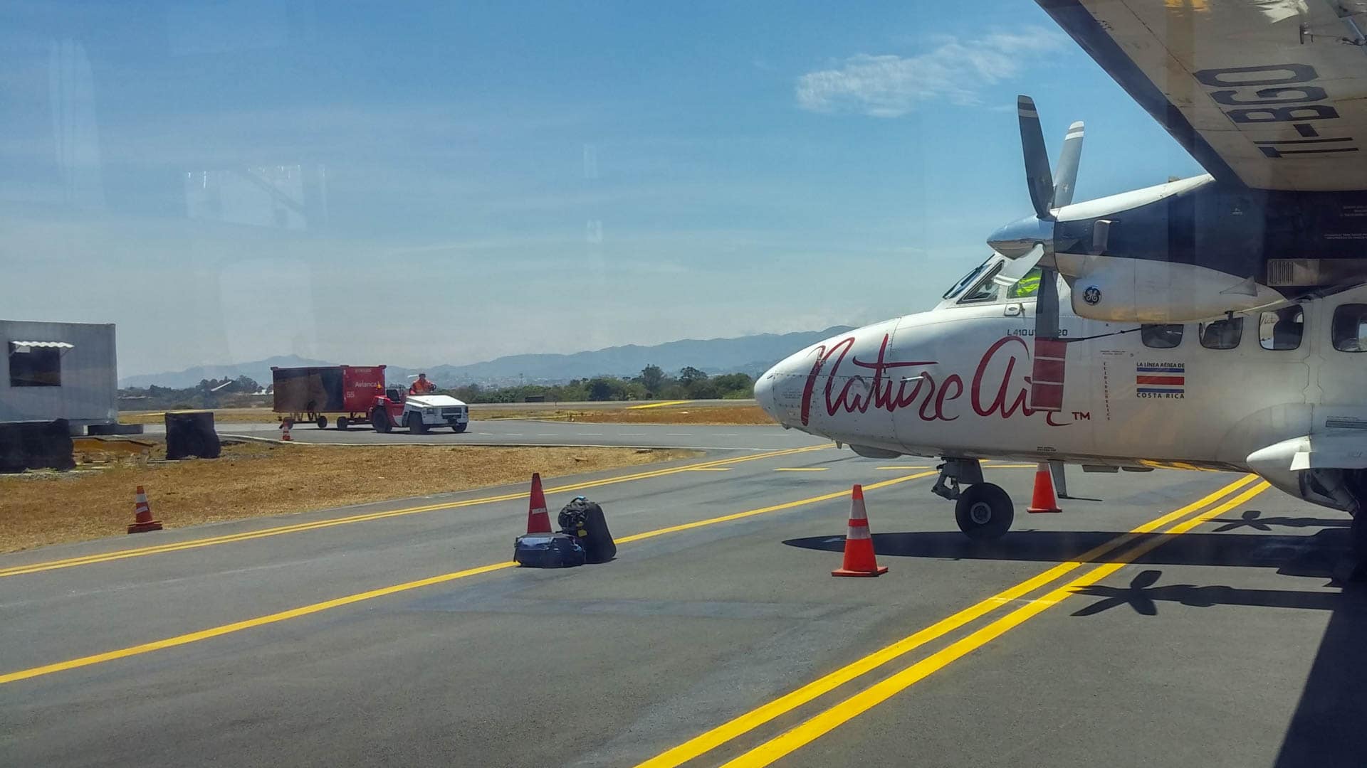 two small bags on tarmac in front of plane
