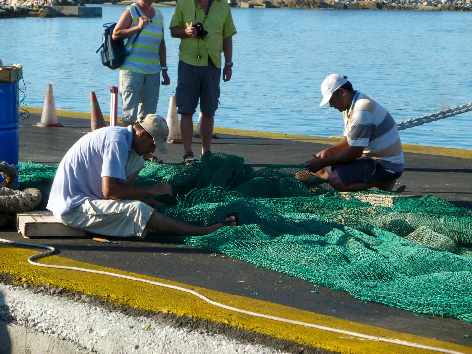 Fishmermen in Naxos harbor working on their nets