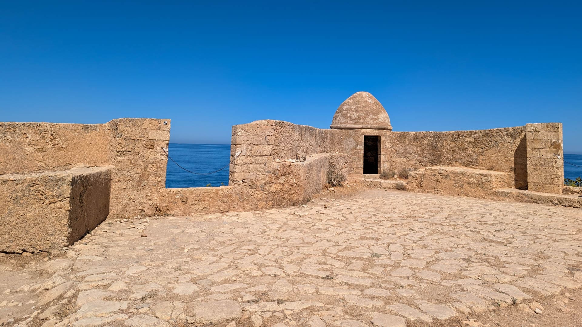 wall with guard tower and water in background